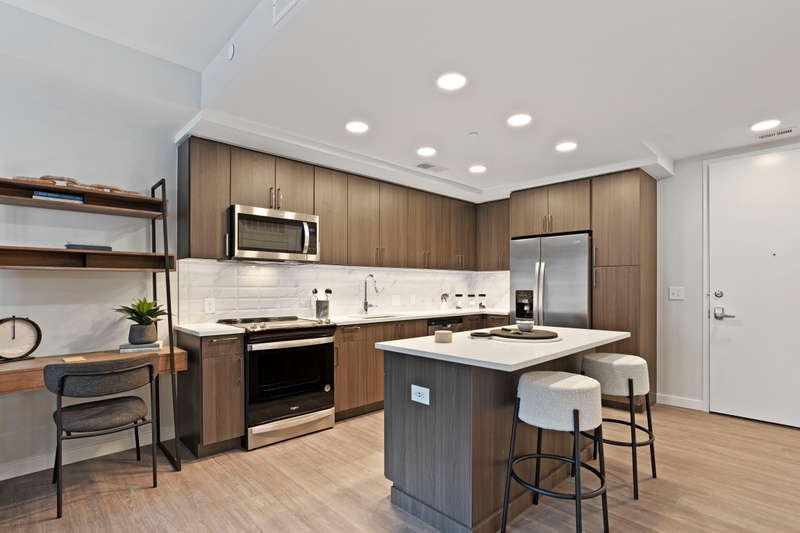 Gourmet Kitchen And Dining Area With White Countertops, Rustic Taupe Cabinets, and Stainless-Steel Appliances