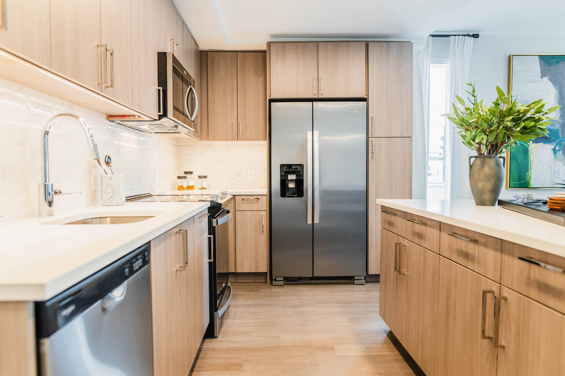 Gourmet Kitchen And Dining Area With White Countertops, Rustic Taupe Cabinets, And Stainless Steel- Appliances