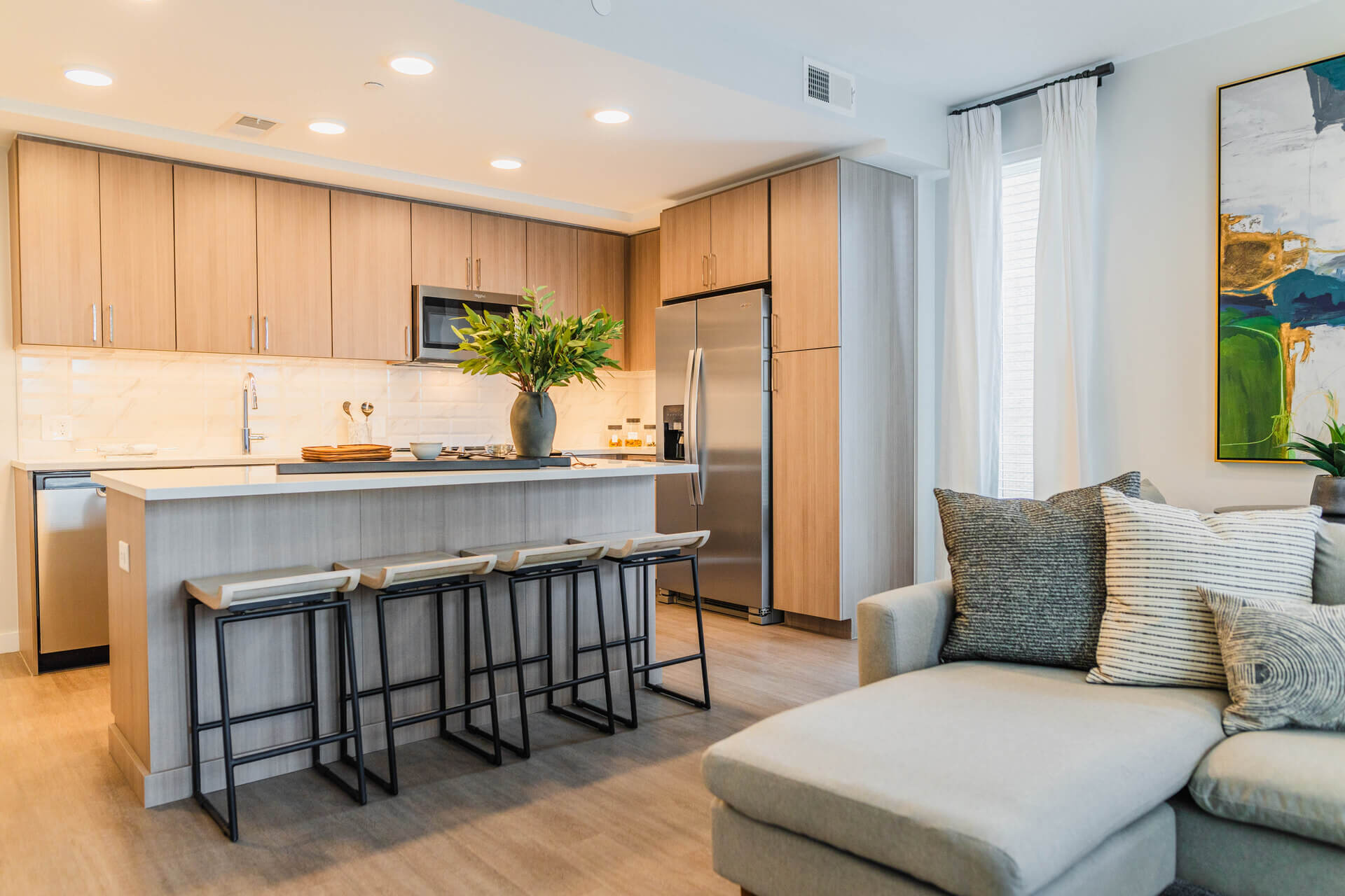 Gourmet Kitchen And Dining Area With White Countertops, Rustic Taupe Cabinets, And Stainless Steel- Appliances